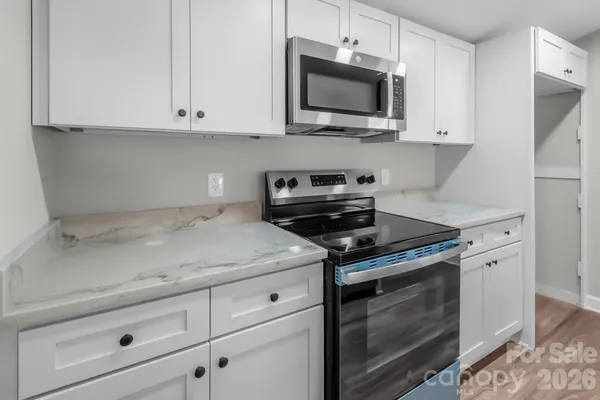 a kitchen with white cabinets stainless steel appliances and a sink