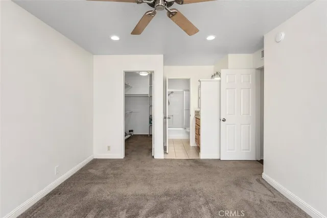 an empty room with a ceiling fan and entryway