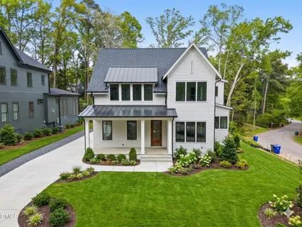 a front view of a house with a yard and potted plants