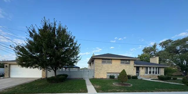 a front view of a house with a yard and trees