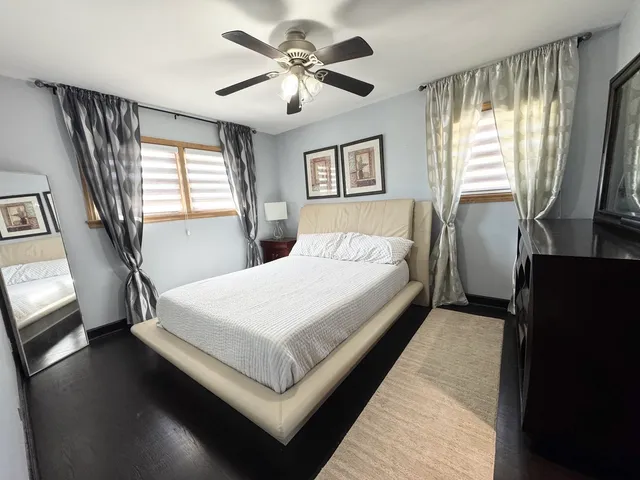 a bedroom with a large bed and a flat tv screen on dresser