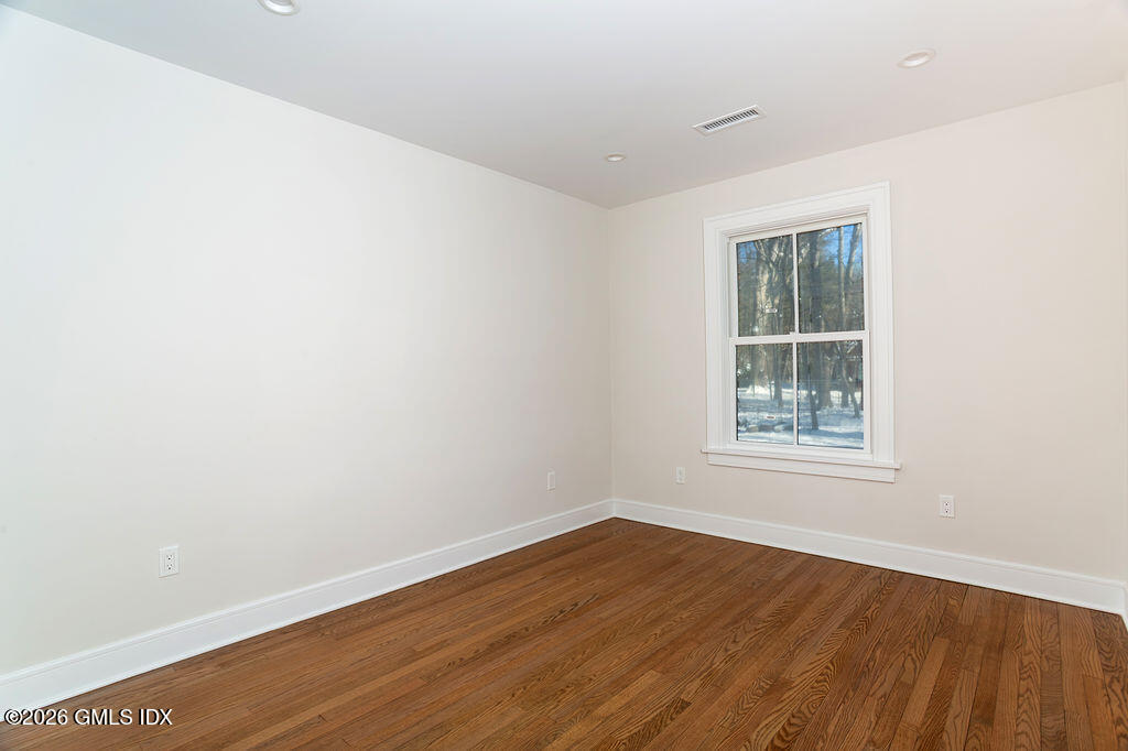 49 Salisbury Road Darien, CT 06820 - Photo 20 of 40 an empty room with wooden floor and windows