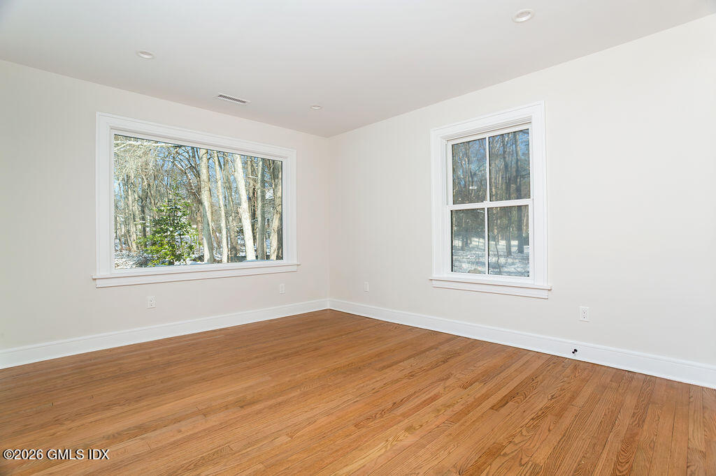 49 Salisbury Road Darien, CT 06820 - Photo 22 of 40 an empty room with wooden floor and windows