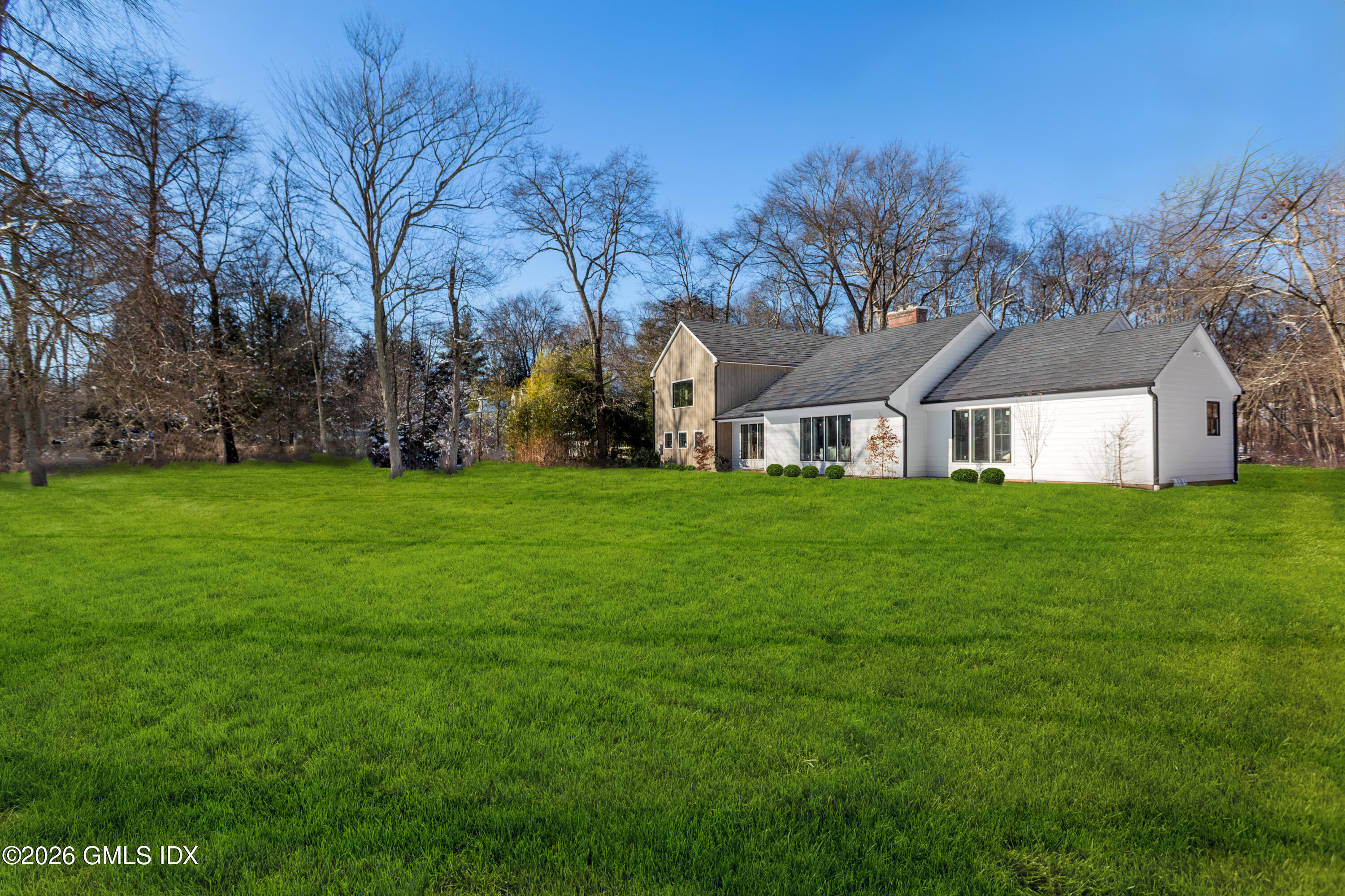 49 Salisbury Road Darien, CT 06820 - Photo 40 of 40 a house that is sitting in the grass and the view of trees