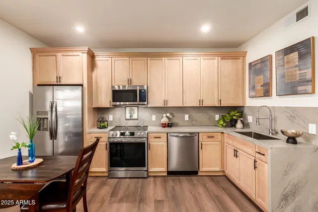 a kitchen with a sink stove and wooden floor
