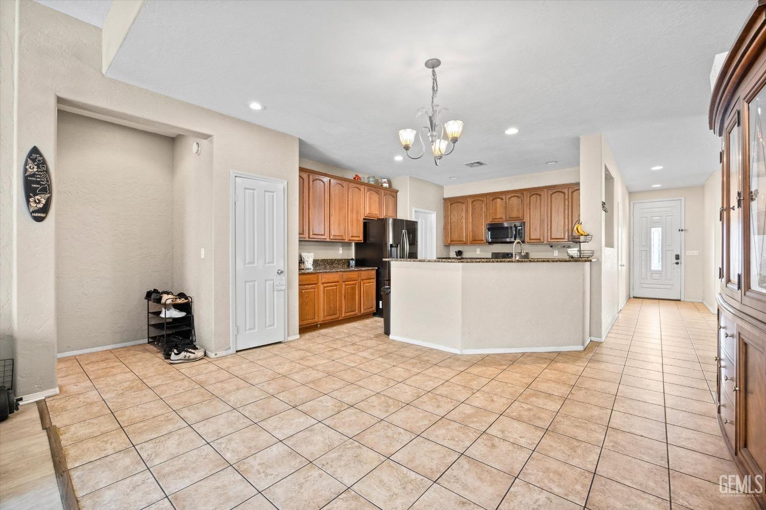 Undisclosed Address Bakersfield, CA 93313 - Photo 12 of 24 a view of a kitchen with kitchen island stainless steel appliances a refrigerator a sink a counter top space and cabinets