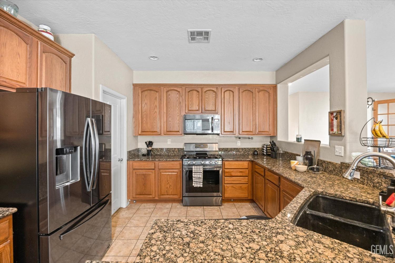 Undisclosed Address Bakersfield, CA 93313 - Photo 15 of 24 a kitchen with stainless steel appliances granite countertop a stove a sink dishwasher a refrigerator and a oven