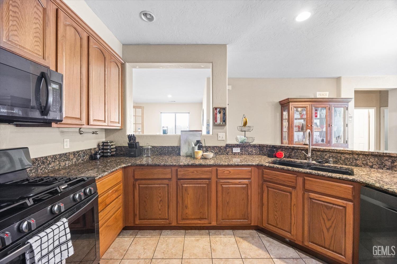 Undisclosed Address Bakersfield, CA 93313 - Photo 16 of 24 a kitchen with a sink stove top oven and cabinets