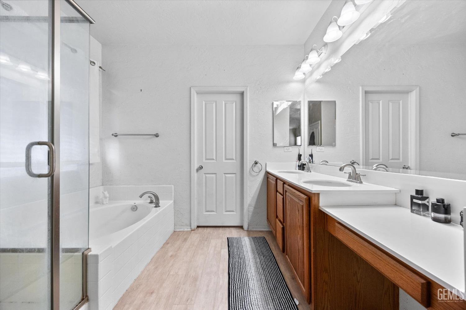 Undisclosed Address Bakersfield, CA 93313 - Photo 17 of 24 a spacious bathroom with a tub sink and mirror