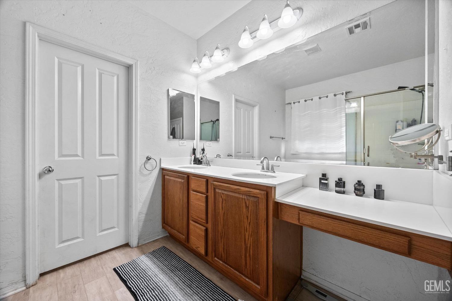 Undisclosed Address Bakersfield, CA 93313 - Photo 18 of 24 a spacious bathroom with a double vanity sink and a mirror