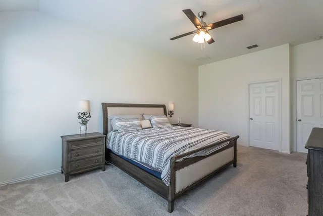 a bedroom with a bed and a ceiling fan