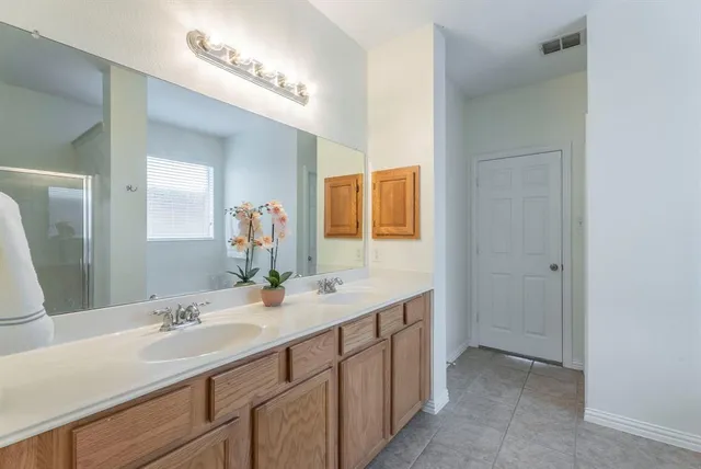 a bathroom with a double vanity sink and a mirror