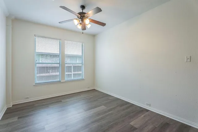 an empty room with wooden floor and window