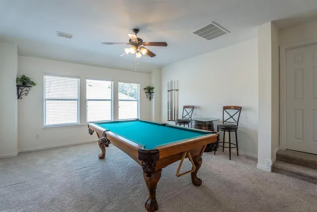 a room with pool table and windows