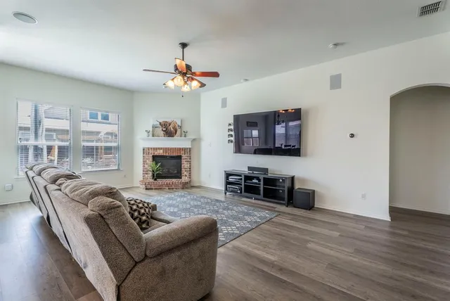 a living room with furniture a fireplace and a flat screen tv