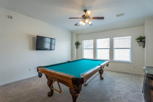 a room with pool table and windows