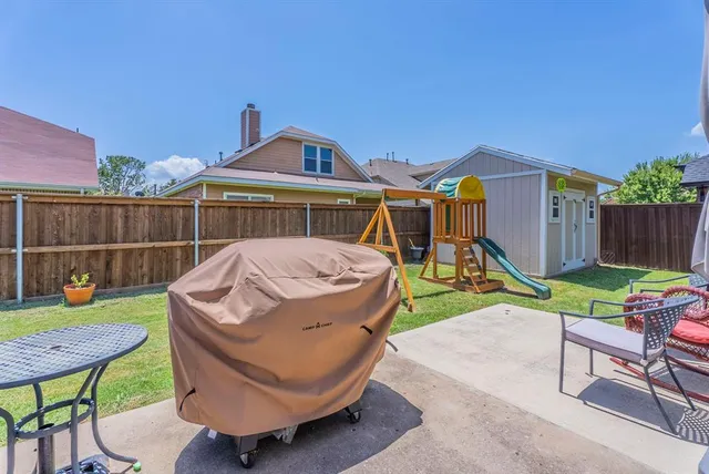 a view of a chair and table in backyard of the house