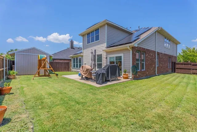 a view of a house with a yard and patio