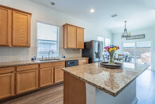 a kitchen with kitchen island granite countertop a sink cabinets and window