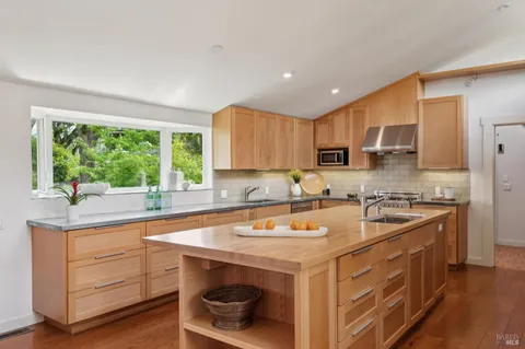 a kitchen with a sink a stove and chairs