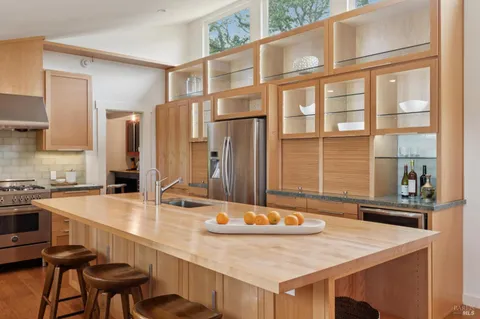 a kitchen with stainless steel appliances a sink refrigerator and cabinets