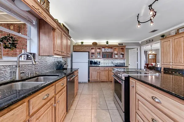 a kitchen with stainless steel appliances granite countertop a sink a stove and cabinets