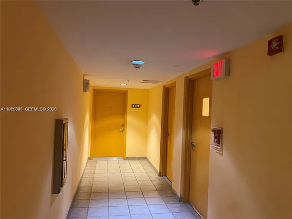 a view of a hallway with a refrigerator and a window