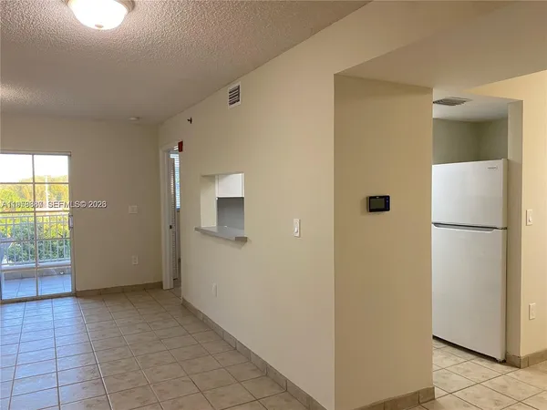 a kitchen with a refrigerator and white cabinets