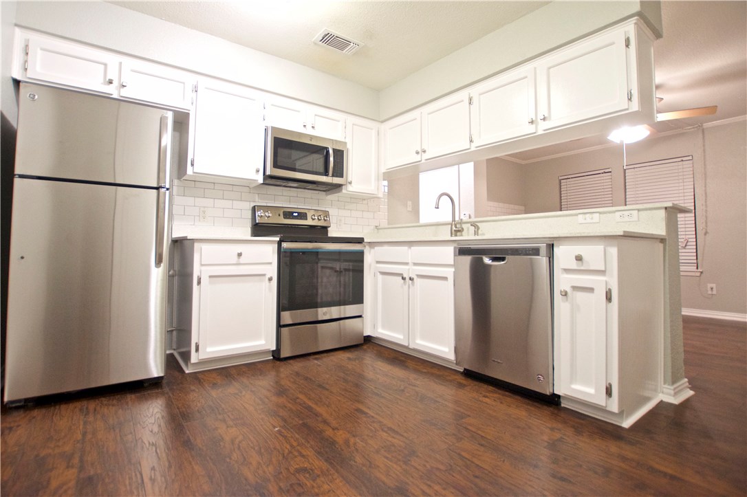 a kitchen with stainless steel appliances a refrigerator sink and microwave