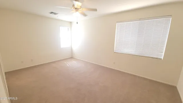 an empty room with a window and a fan