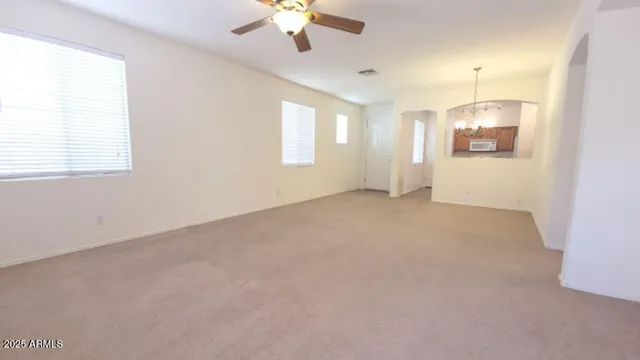 en empty room with windows and fan