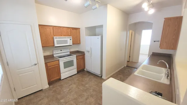 a kitchen with white cabinets and white appliances