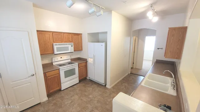 a kitchen with white cabinets and white appliances