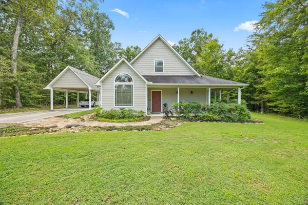 a front view of a house with a yard and trees