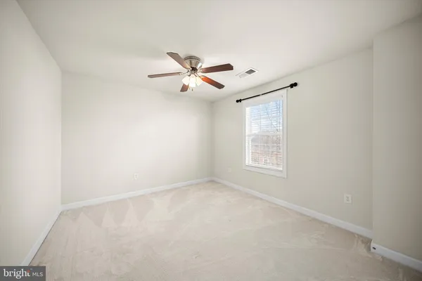 a view of room with a ceiling fan and window