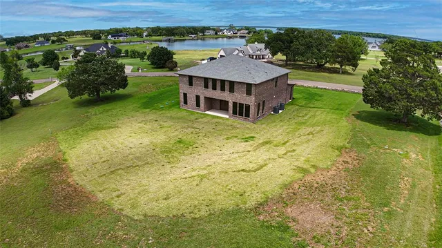 a view of a swimming pool with lawn chairs and a yard