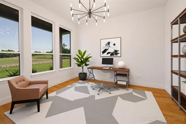 an empty room with wooden floor fireplace and windows