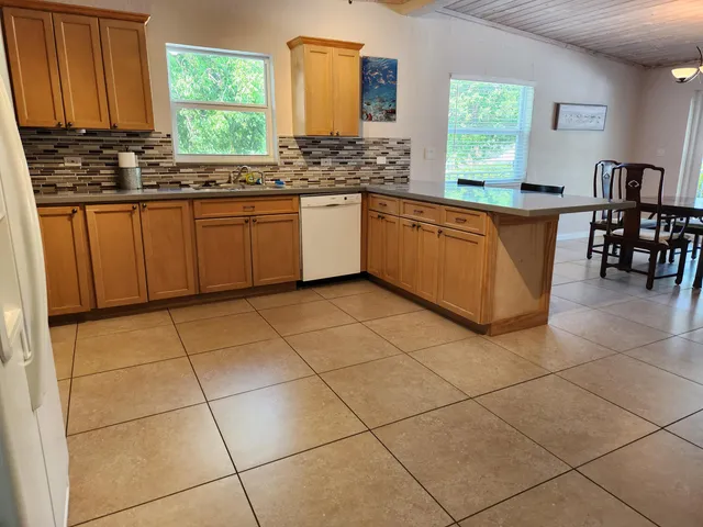 a kitchen with stainless steel appliances a sink a counter top space cabinets and a window