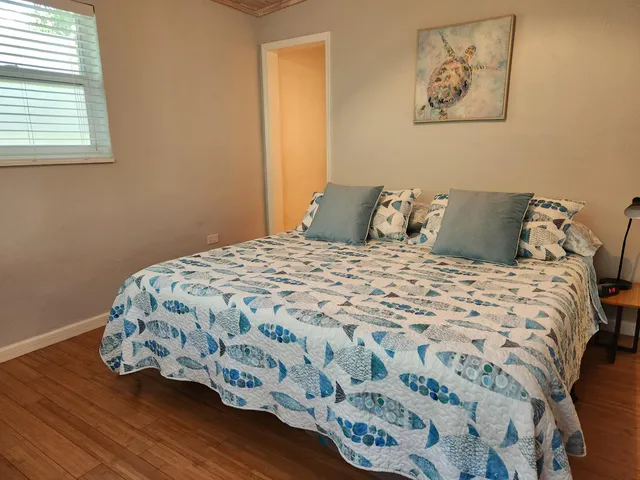 a bedroom with a bed and wooden floor