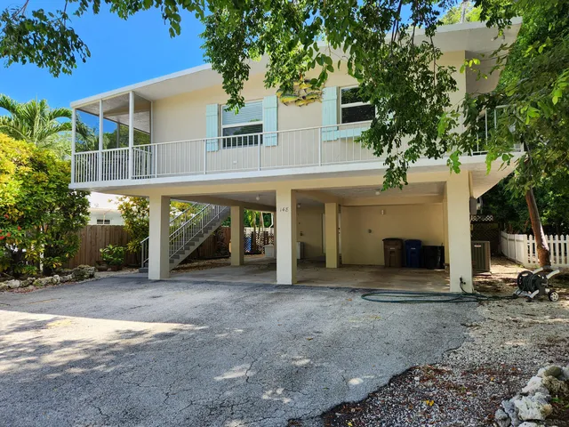 a view of a house with a porch and a tree