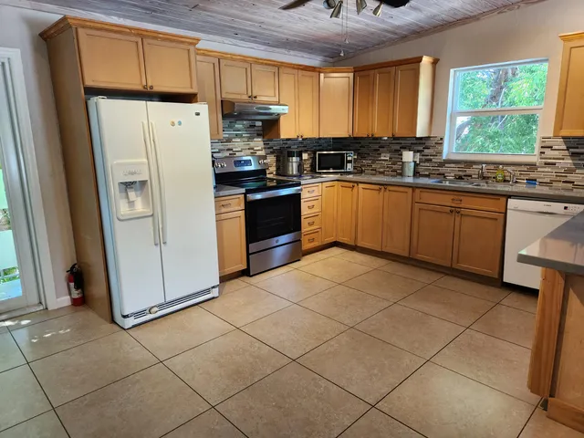 a kitchen with a refrigerator a stove a sink and a window