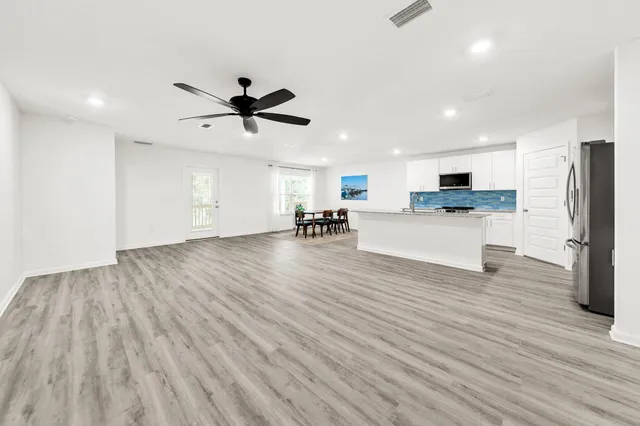 a view of a kitchen with cabinets stainless steel appliances and wooden floor