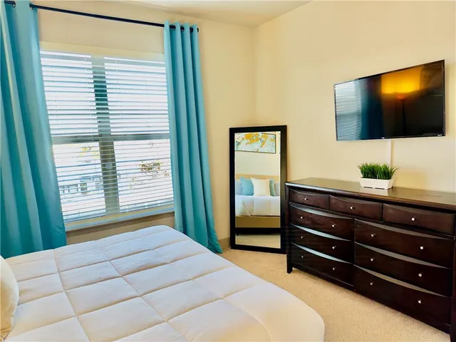 a bedroom with a bed and a flat screen tv