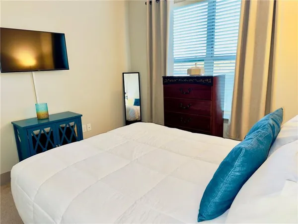 a bedroom with a bed and a flat screen tv