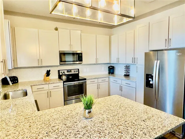 a kitchen with a refrigerator stove and white cabinets