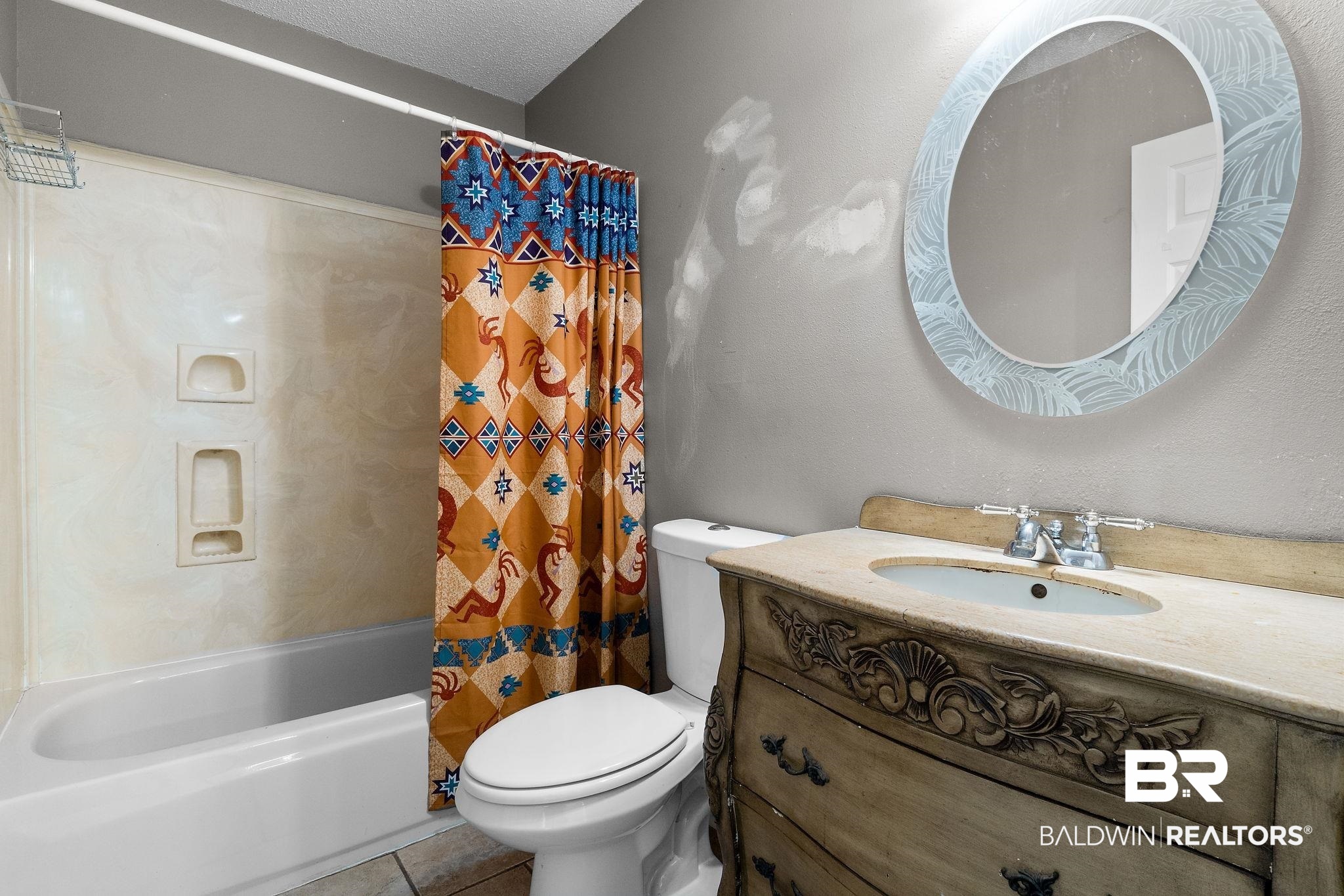 33135 Collier Road Lillian, AL 36549 - Photo 22 of 30 Bathroom featuring vanity, shower / bathtub combination with curtain, tile patterned flooring, and a textured ceiling