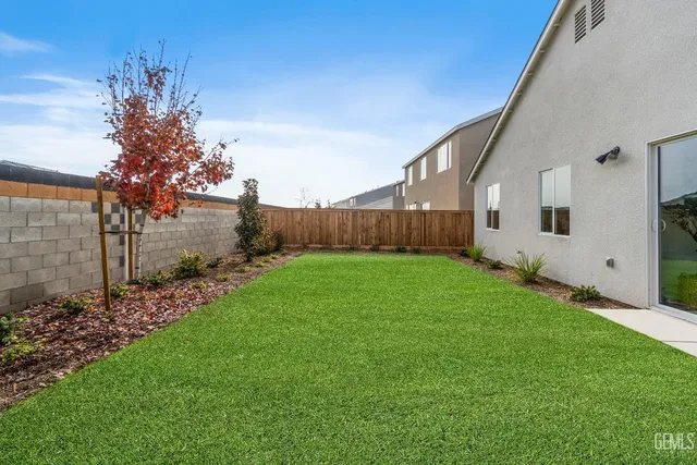 a view of a backyard with potted plants and large tree