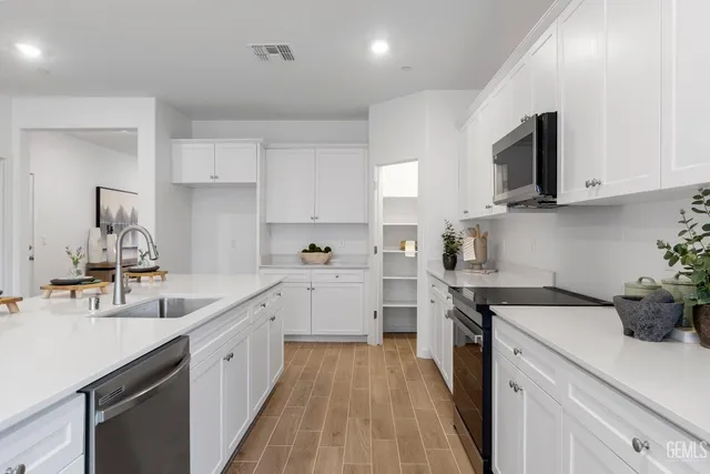 a kitchen with sink a microwave and cabinets