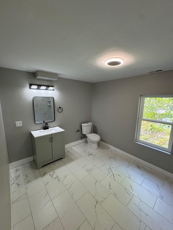 32 Main Street Monson, MA 01057 - Photo 39 of 42 a bathroom with a toilet a sink a mirror and a window