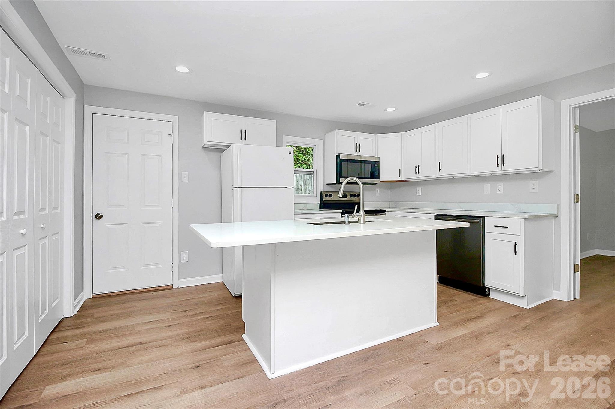 315 South Ransom Street Gastonia, NC 28052 - Photo 7 of 18 a kitchen with kitchen island a white counter top space cabinets and stainless steel appliances